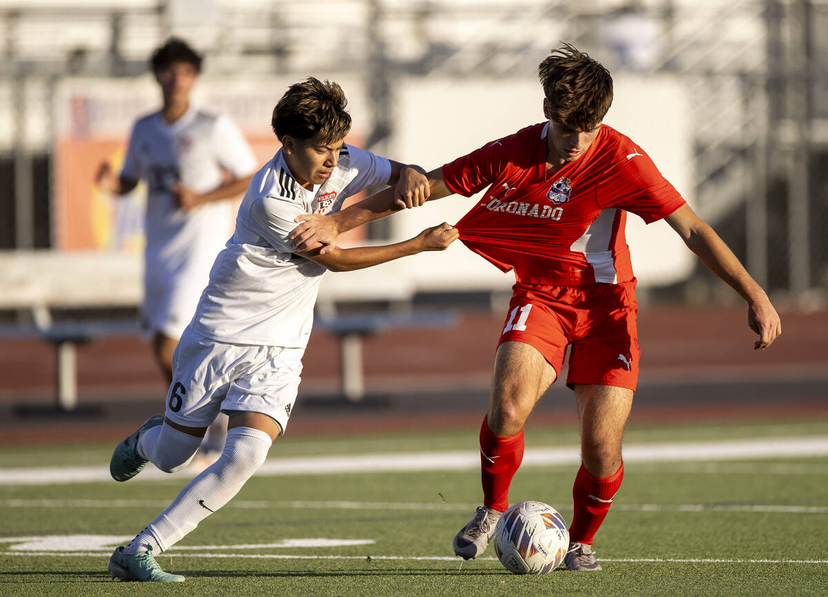 Coronado junior Gavin Flickinger (11) and Las Vegas High midfielder Israel Pelaez Jr. (6) compe ...