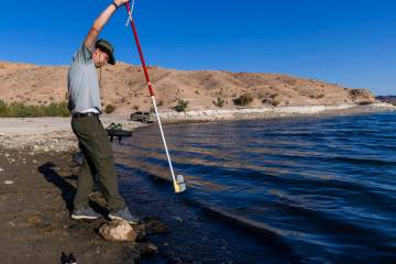 Aquatic Ecologist Riley Rackliffe with the National Park Service draws a water sample looking f ...