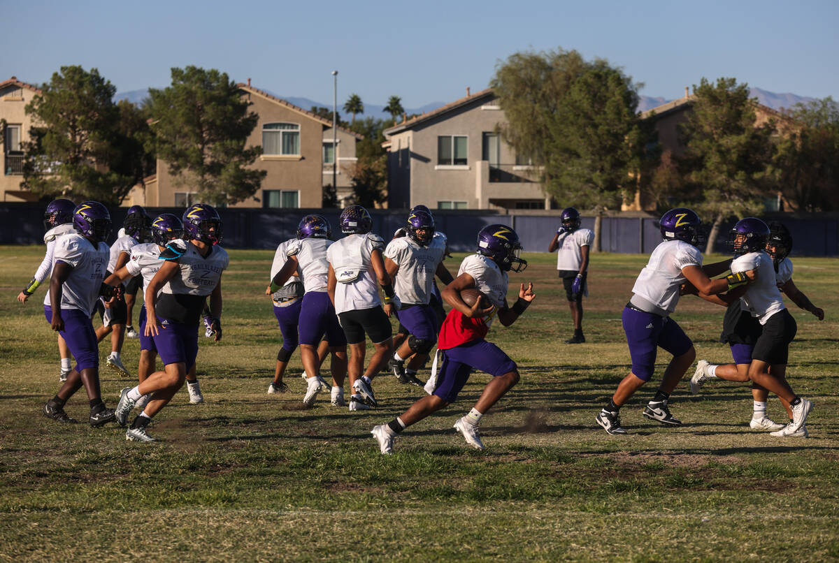 Running back Makai Miller runs with the ball during football practice at Durango High School in ...