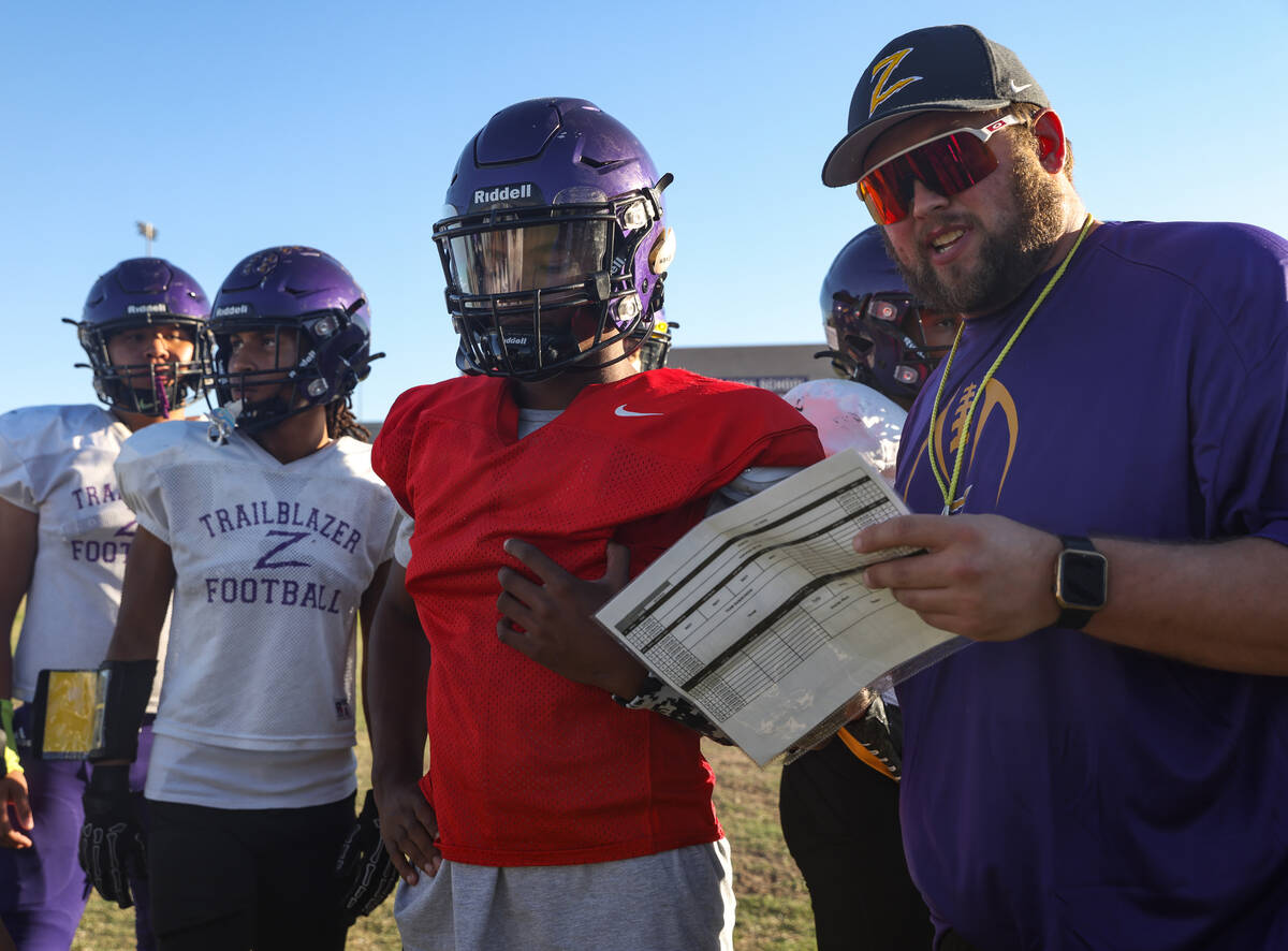 Quarterback Alexander Mercurius speaks with offensive coordinator Jeremy Stiles during football ...