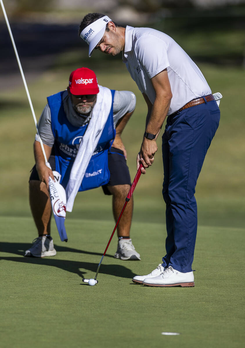 Beau Hossler sets up a putt as his caddie double checks the line at hole #7 during the opening ...