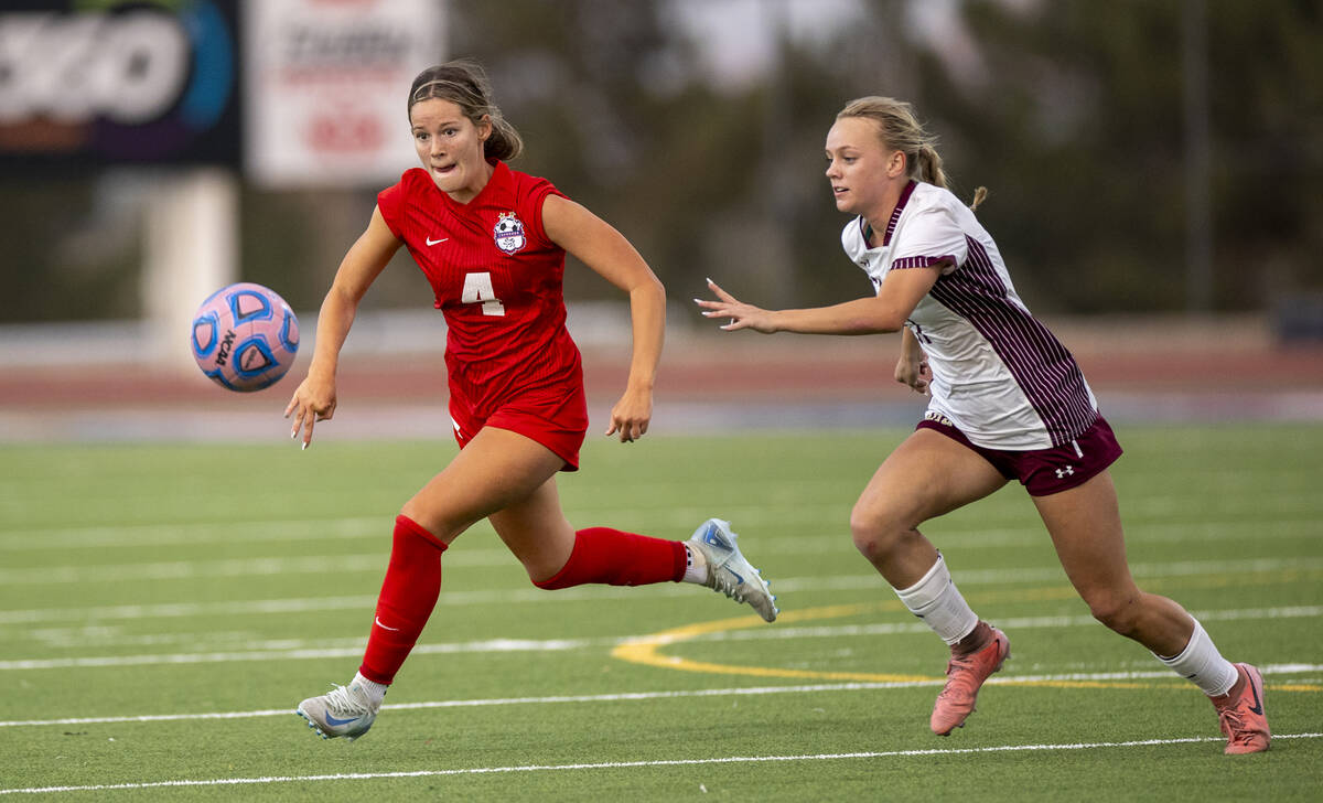 Coronado defender Ella Schultz (4) and Faith Lutheran sophomore Julia Anfinson (17) run after t ...