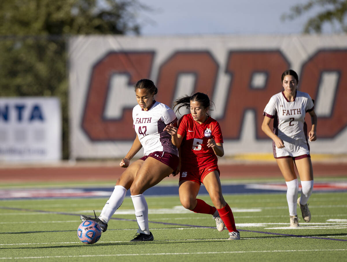 Faith Lutheran midfielder Jailynn Henry (42) and Coronado forward Abby Obregon (5) compete for ...