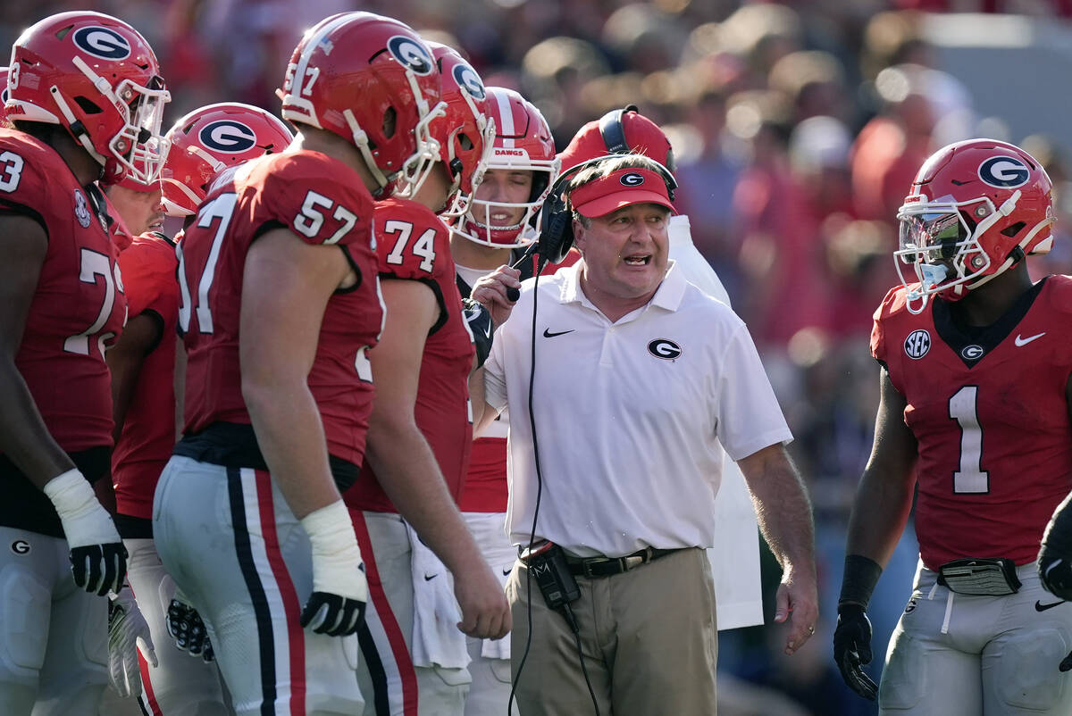 Georgia head coach Kirby Smart talks with his players in the first half of an NCAA college foot ...