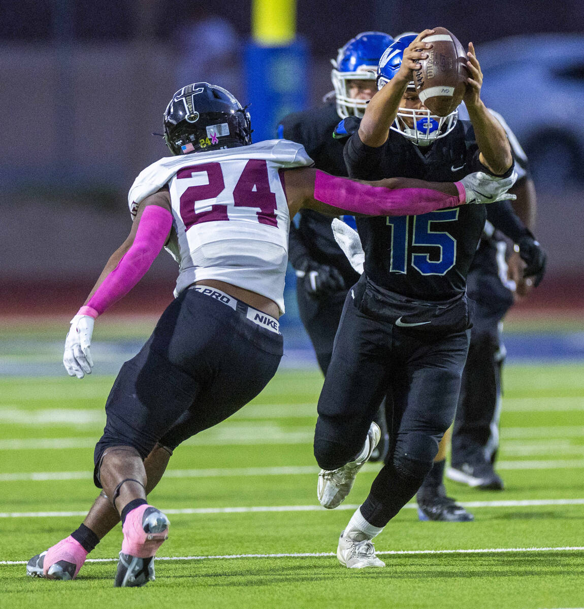 Green Valley quarterback Michael Lewis (15) attempts to break a tackle by Faith Lutheran lineba ...