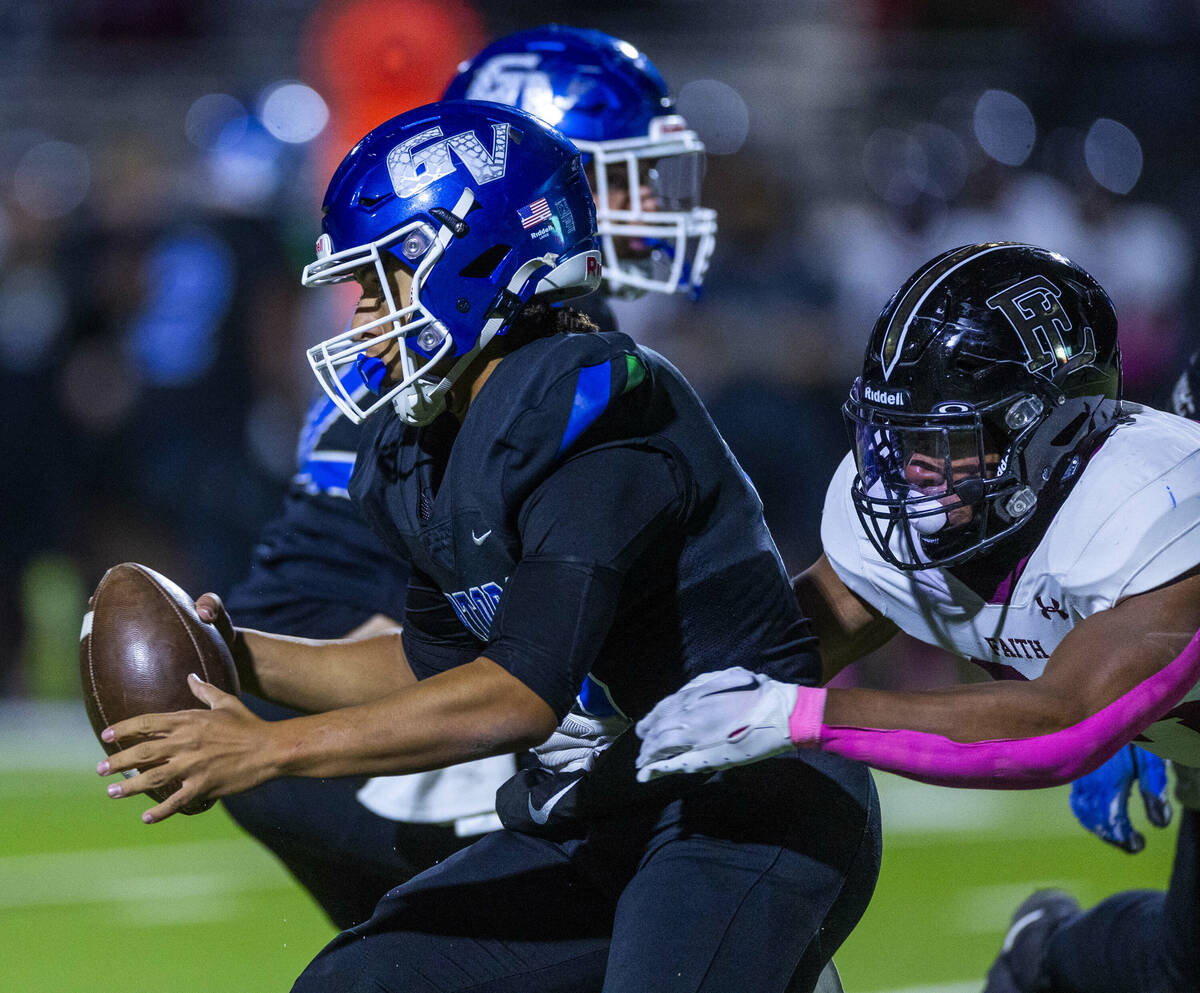 Green Valley quarterback Michael Lewis (15) is sacked by Faith Lutheran linebacker Ricky Mannin ...