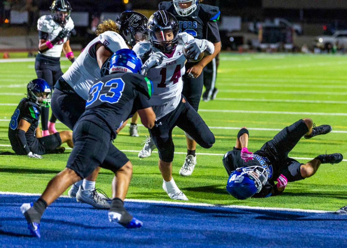 Faith Lutheran running back Cale Breslin (14) scores as Green Valley defensive end Nash Wilkins ...