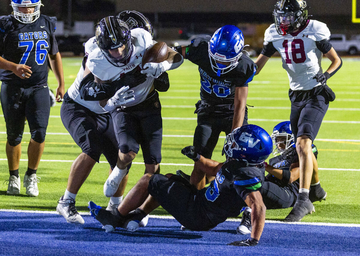 Faith Lutheran running back Cale Breslin (14) scores as Green Valley defensive end Nash Wilkins ...