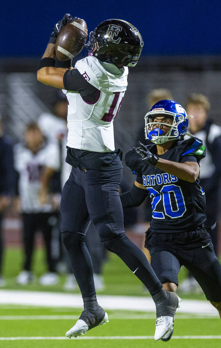 Faith Lutheran wide receiver Aipa Kuloloia (12) elevates for a reception attempt as Green Valle ...