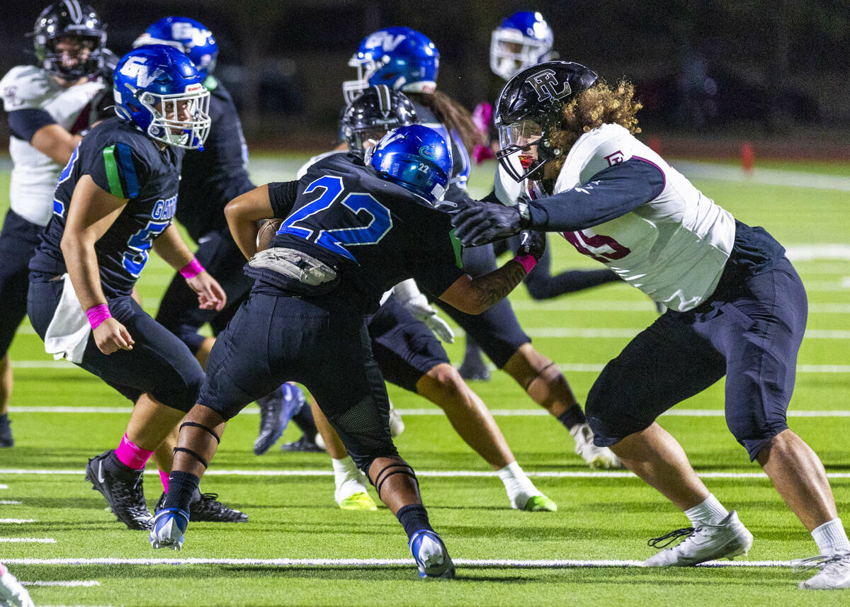 Green Valley running back Chris Dalina (22) is stopped behind the line by Faith Lutheran defens ...