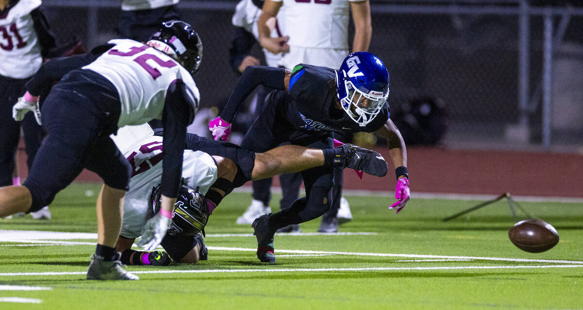 Faith Lutheran offensive lineman Carter Besser (57) hits and dislodges the ball from Green Vall ...