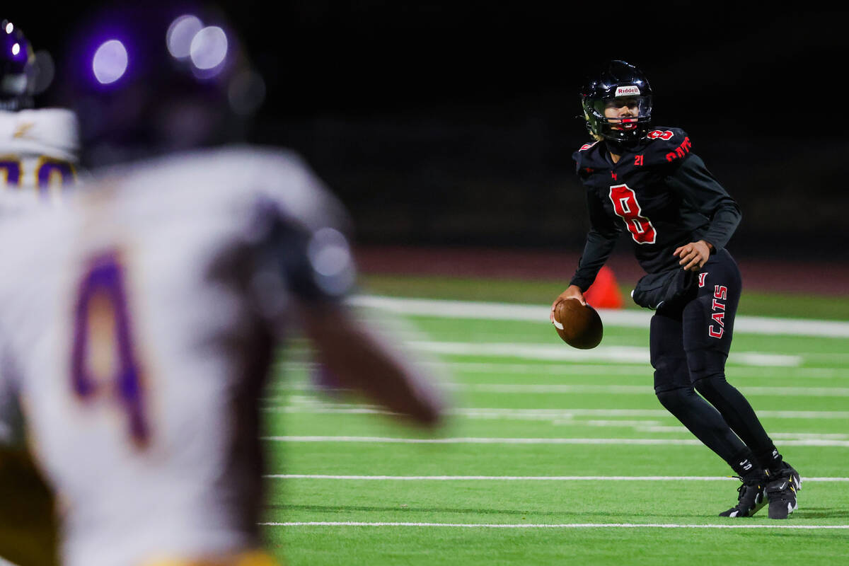 Las Vegas quarterback Tanner Vibabul (8) runs out of the pocket to throw the ball during a high ...