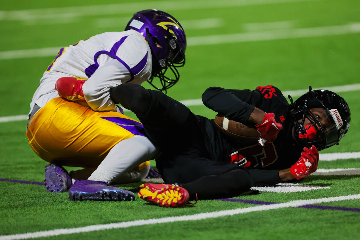 Las Vegas wide receiver Mychael Walker goes down with the ball during a high school football ga ...