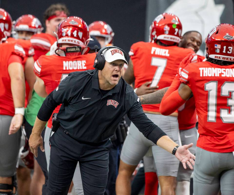 UNLV head coach Barry Odom welcomes players back to the sideline after scoring a touchdown duri ...