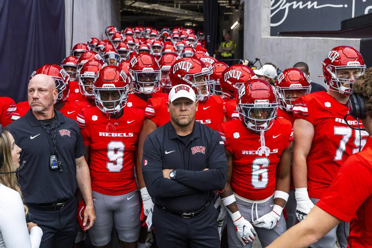 UNLV Head Coach Barry Odom and players await introduction as the ready to face the Fresno State ...