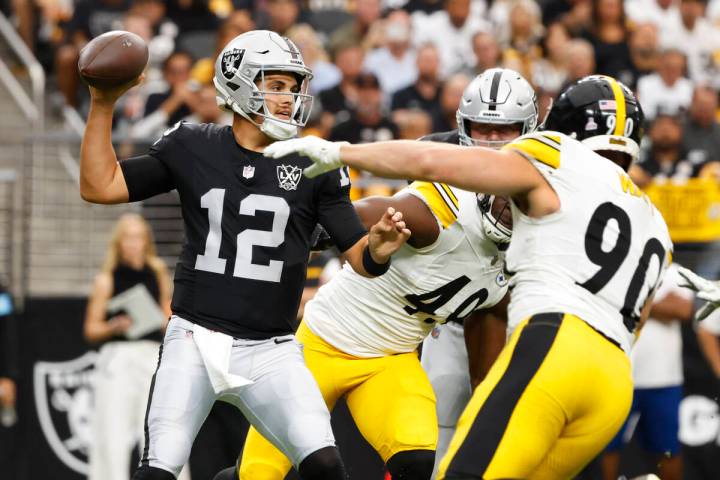 Raiders quarterback Aidan O'Connell (12) throws under pressure from Pittsburgh Steelers linebac ...