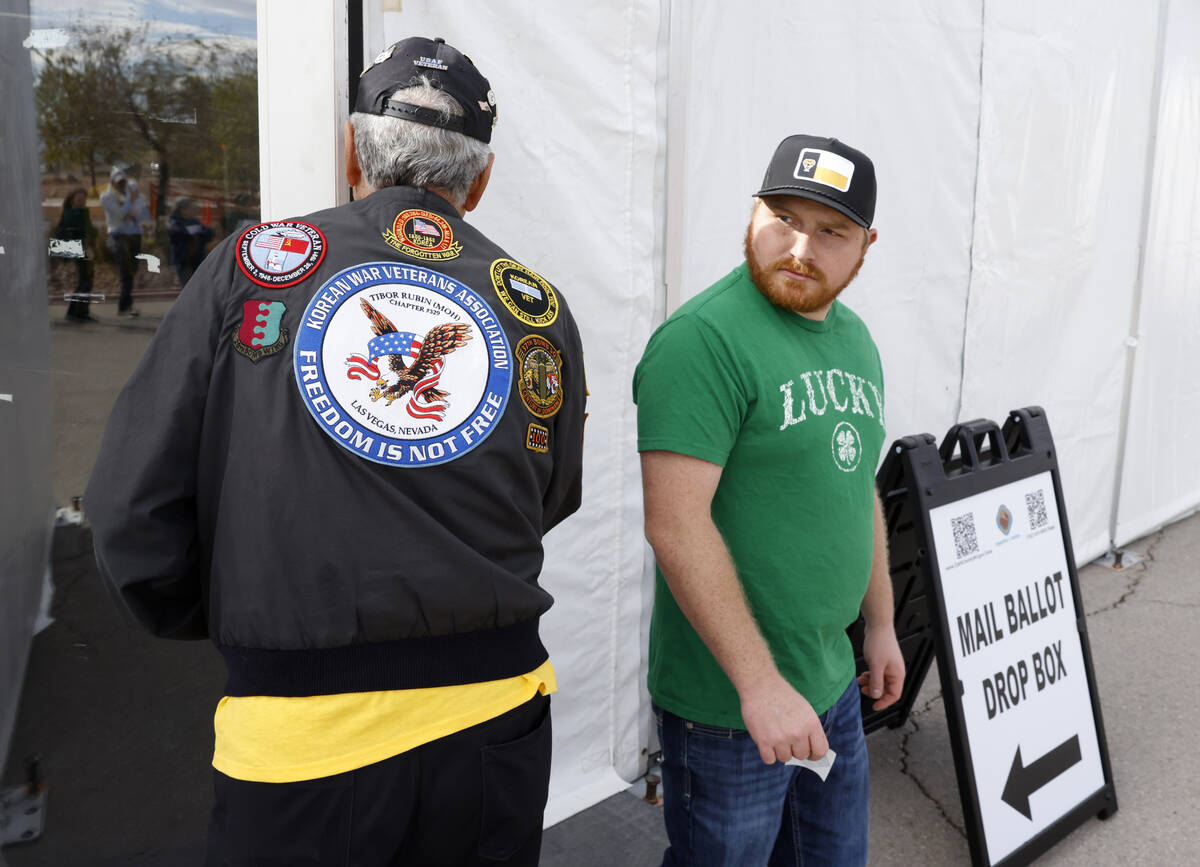 U.S. Air Force Korean War veteran Lee Mowery, 92, holds the door as a voter exits after casting ...