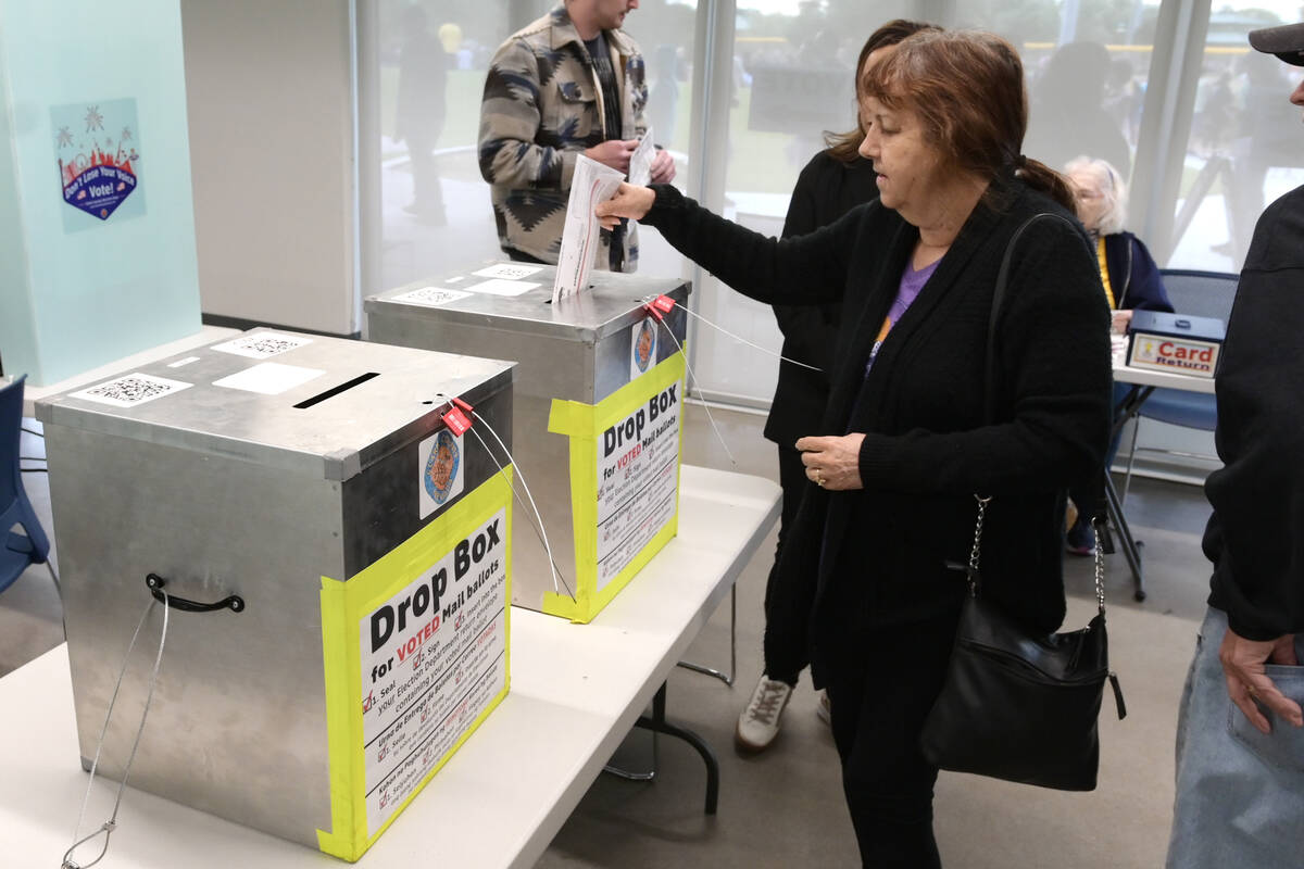 Arlene Bell puts her ballot into a drop box at the Silverado Ranch Community Center during the ...