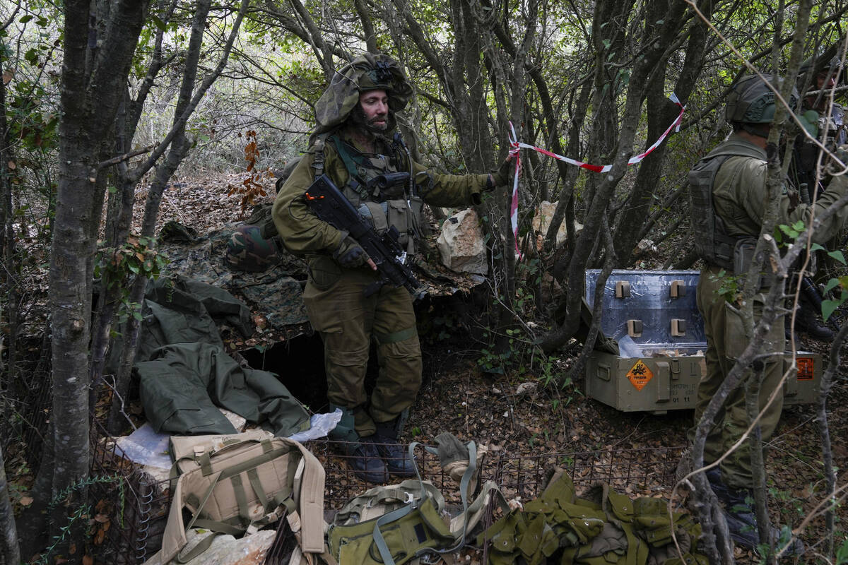 Israeli soldiers display what they say are Hezbollah ammunition and explosives found during the ...