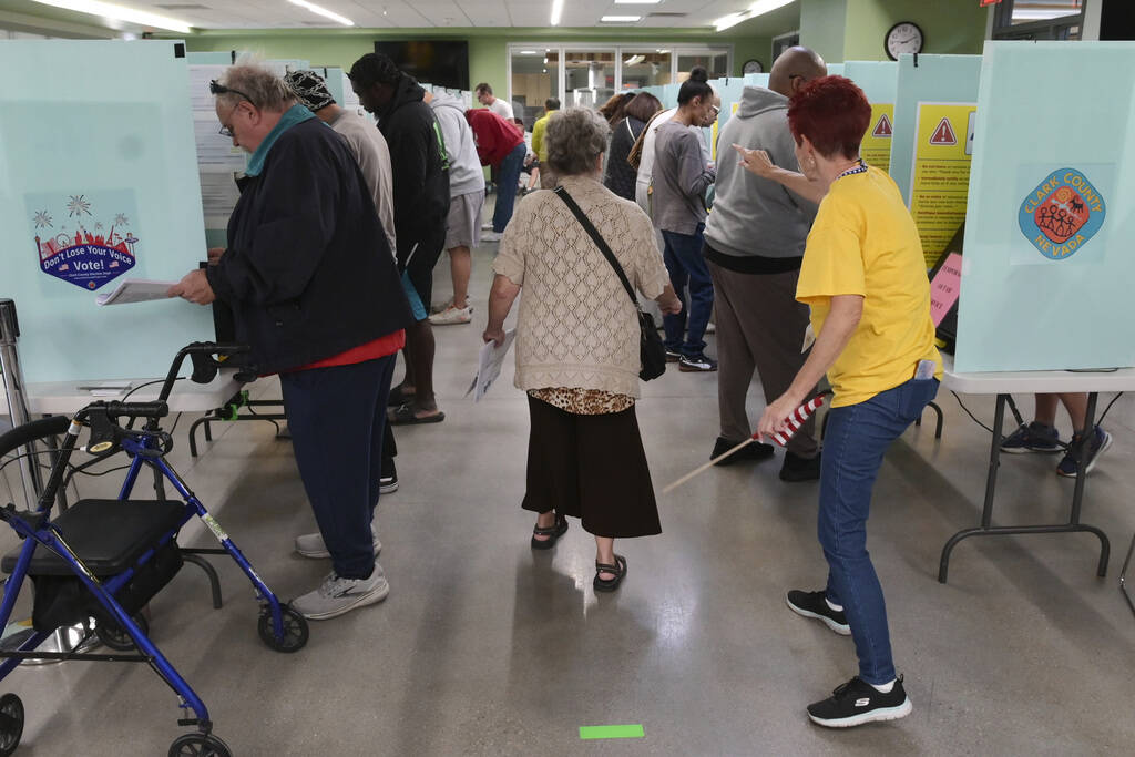 A voter is directed to an available voting booth at the Silverado Ranch Community Center, Satur ...