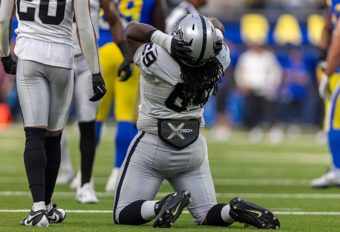 Raiders defensive tackle Adam Butler (69) grabs his helmet after missing an opportunity to crea ...