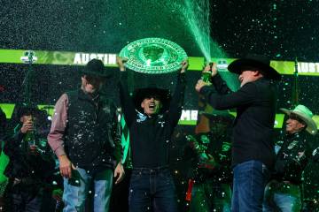 The Austin Gamblers’ Jose Vitor Leme holds the trophy as teammates open bottles of champ ...