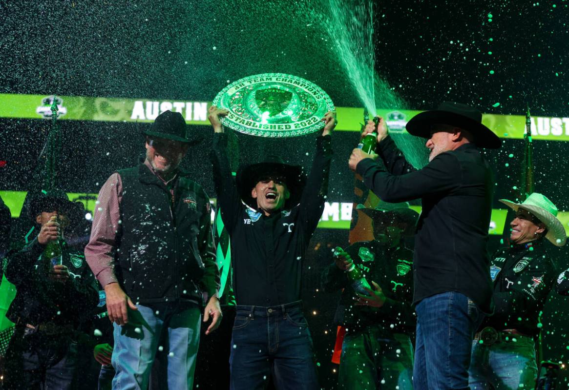 The Austin Gamblers’ Jose Vitor Leme holds the trophy as teammates open bottles of champ ...