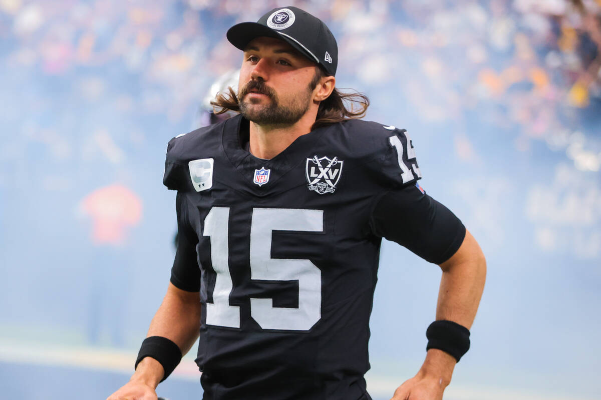 Raiders quarterback Gardner Minshew runs onto the field during an NFL football game between the ...