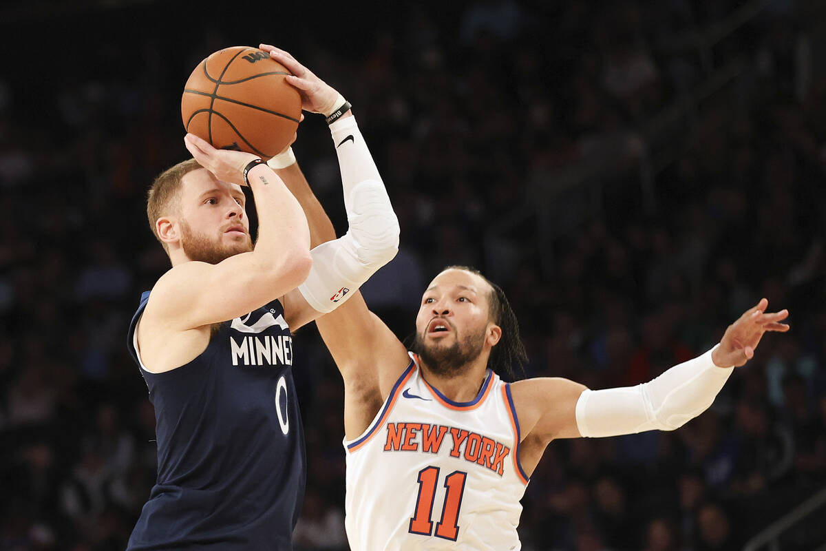 Minnesota Timberwolves guard Donte DiVincenzo, left, is defended by New York Knicks guard Jalen ...