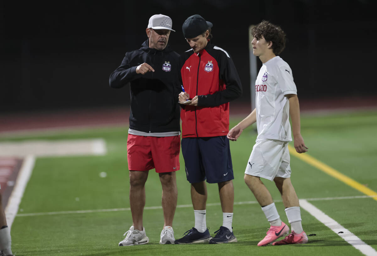 Coronado head coach Dustin Barton, center, takes notes during a break in a soccer game at Palo ...