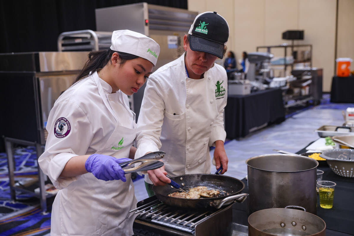 Gabriela Lim, 15, from Silverado High school, gets help from Chef Rachel Reed-Sanow at the Scho ...