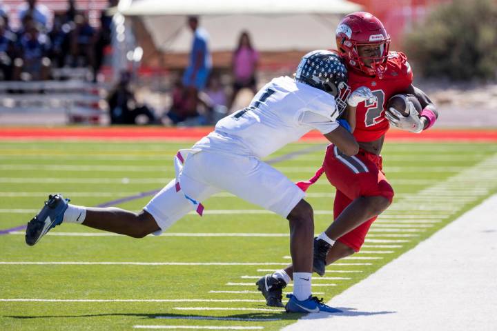 Desert Pines senior Ejuan Carter (1) pushes Arbor View running back Sean Moore (2) out of bound ...