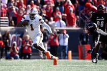 Miami quarterback Cam Ward (1) runs from the pursuit of the Louisville defense during the secon ...