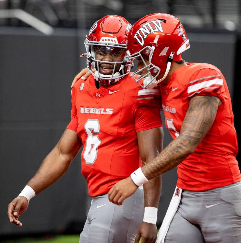 UNLV quarterback Hajj-Malik Williams (6) and quarterback Cameron Friel (7) talk before the coll ...