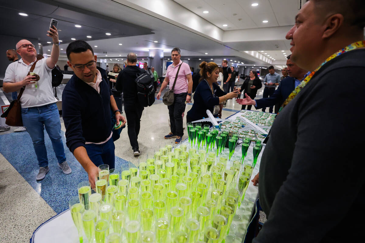 Luciano Yamanaka, of Dublin, grabs some champaign laid out for passengers following Air Lingus& ...