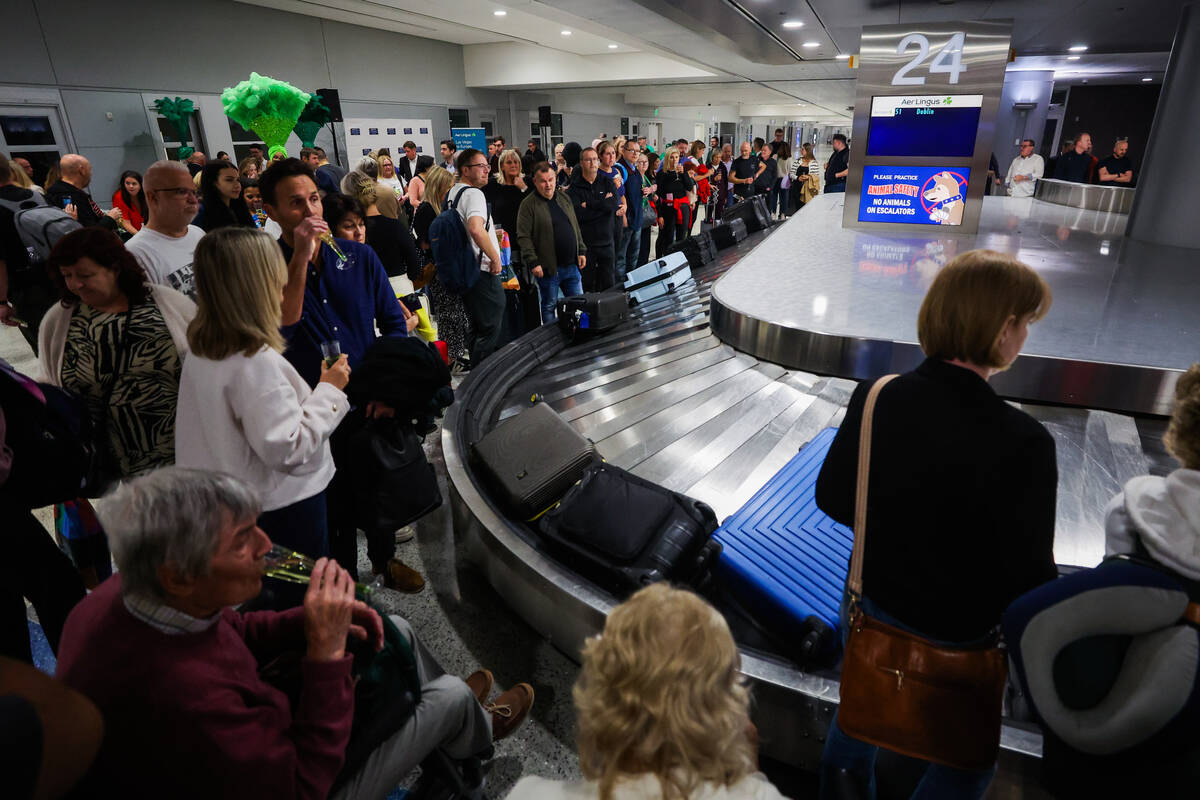 Passengers wait for their baggage following Air Lingus’ first nonstop flight from Dublin ...