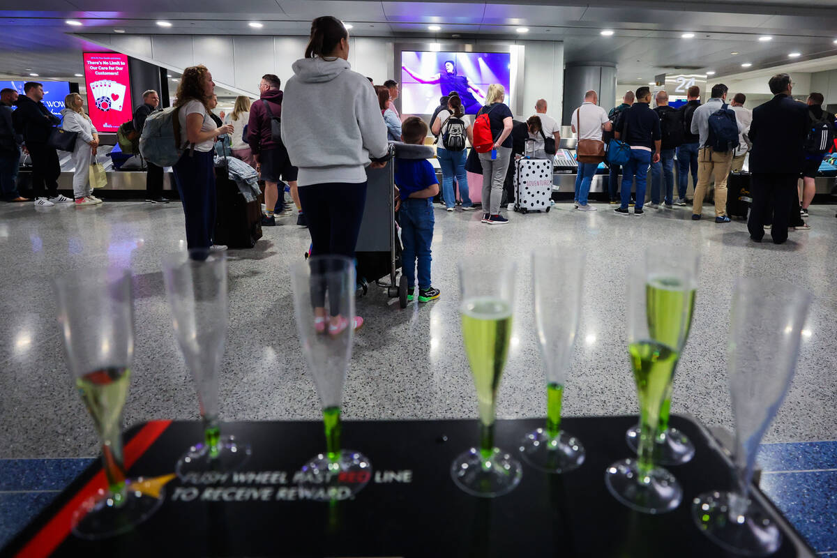 Champagne glasses lay out as travelers await their baggage at baggage claim following Air Lingu ...