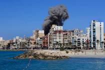 Smoke rises from buildings hit in an Israeli airstrike in Tyre, Lebanon, Wednesday, Oct. 23, 20 ...