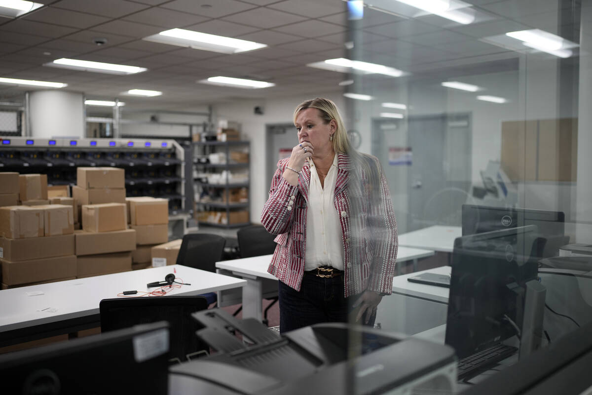 Cari-Ann Burgess, interim Registrar of Voters for Washoe County, Nev., pauses while helping pre ...