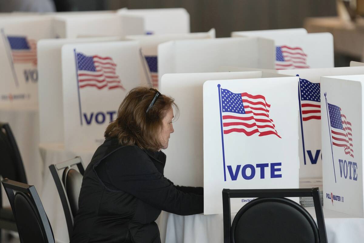 A voter fills out her ballot for the Michigan primary election in Grosse Pointe Farms, Mich., T ...