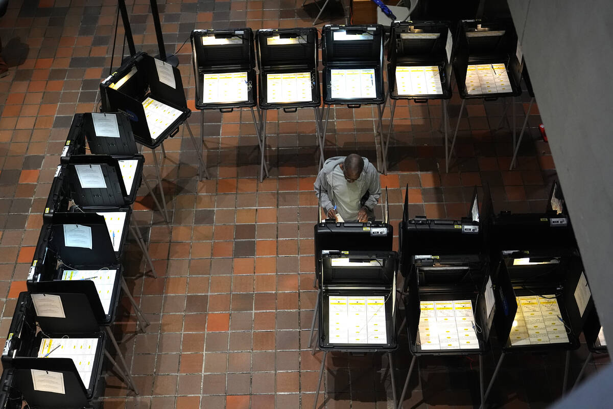 A person votes on the first day of early voting in the general election, Oct. 21, 2024, in Miam ...