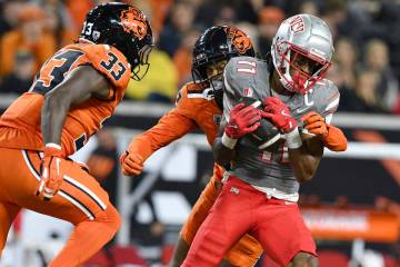 UNLV wide receiver Ricky White III (11) catches a pass in front of Oregon State defensive back ...