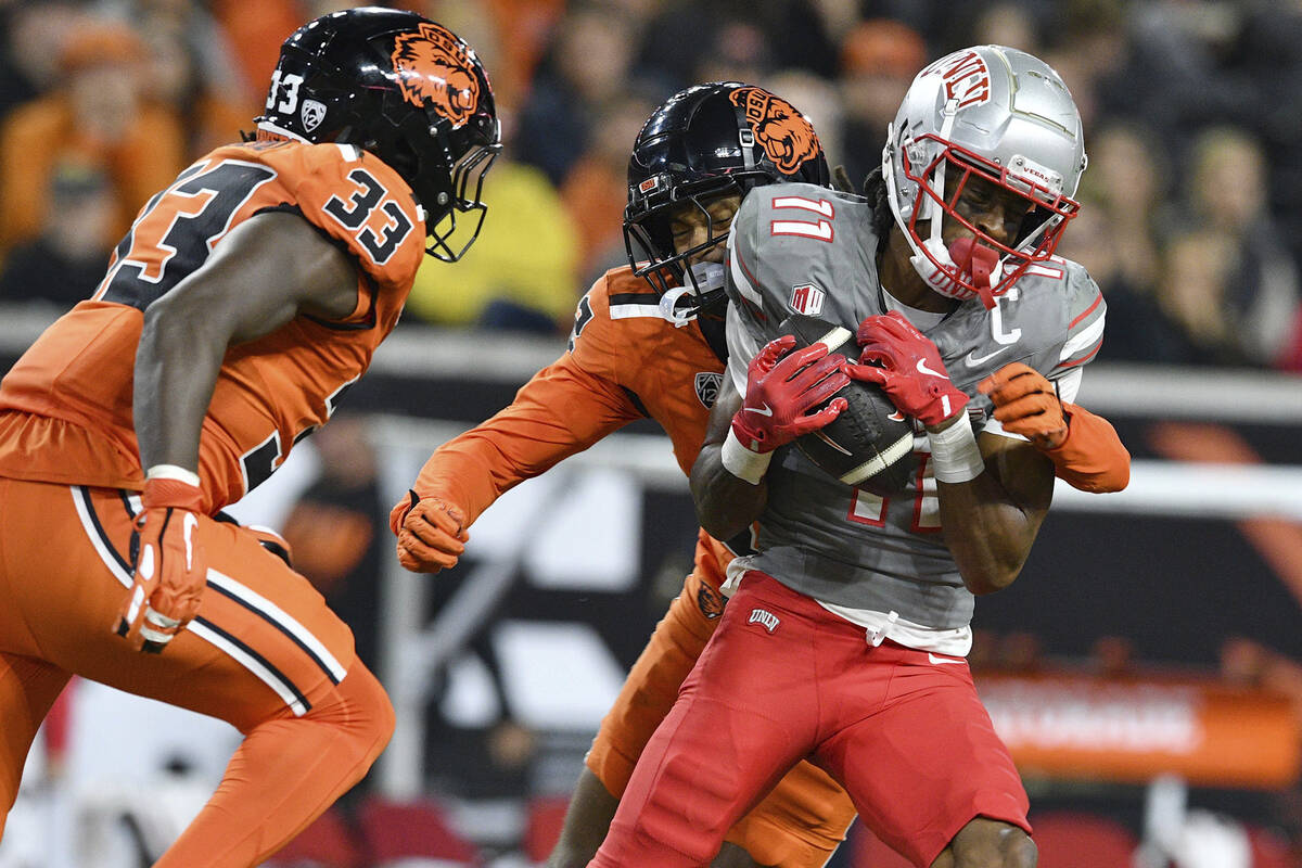 UNLV wide receiver Ricky White III (11) catches a pass in front of Oregon State defensive back ...