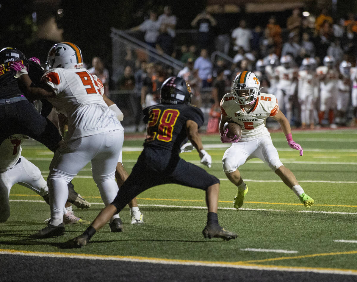 Mojave senior Miguel Reinares (5) runs with the ball during the high school 4A Desert League ti ...