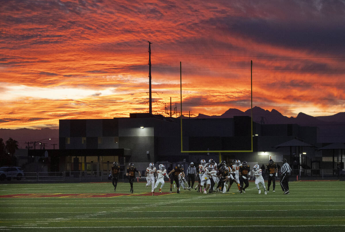 Losee runs the ball as the sun sets during the high school 4A Desert League title football game ...