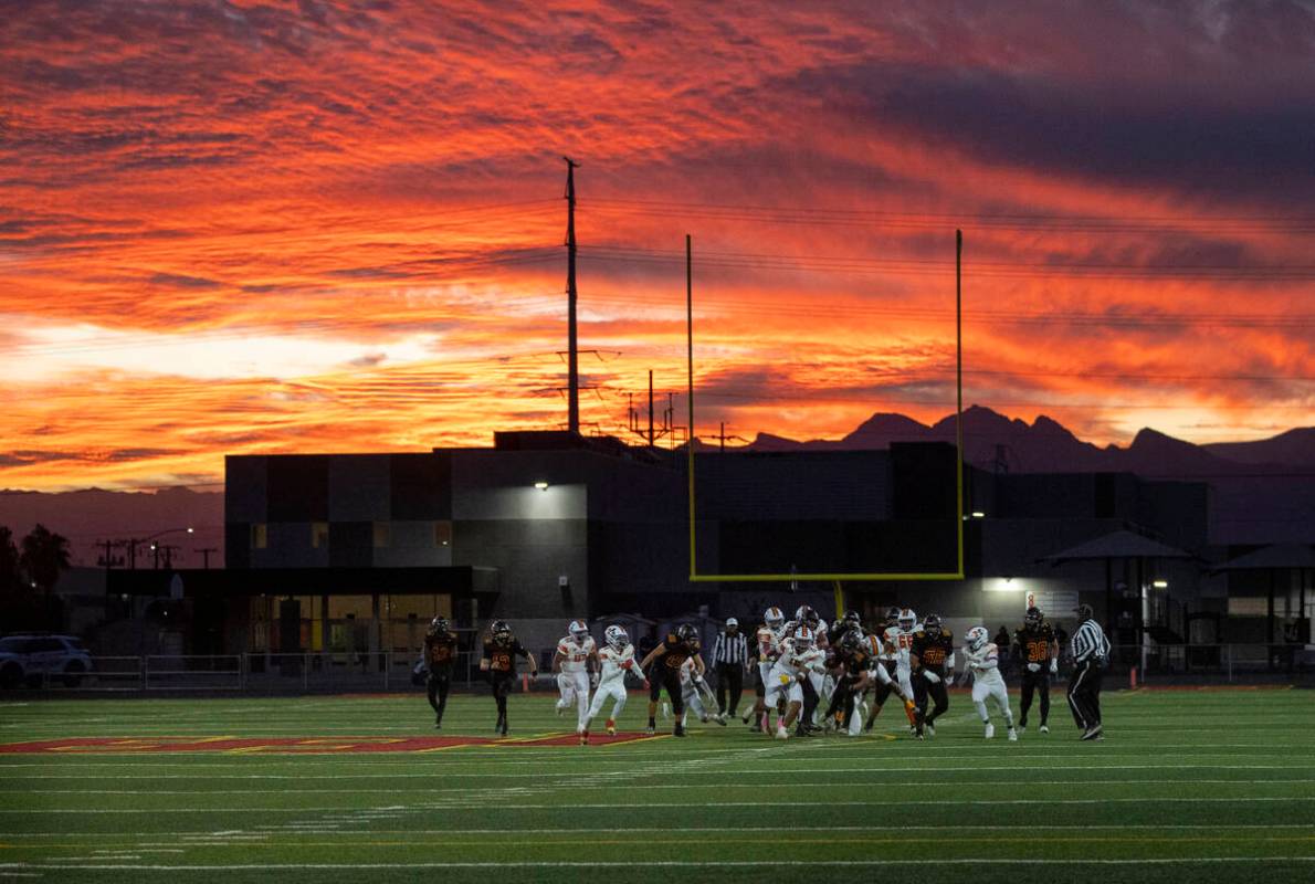 Losee runs the ball as the sun sets during the high school 4A Desert League title football game ...