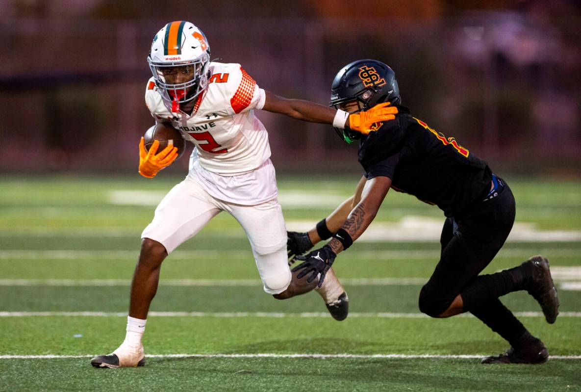 Mojave senior Arthur AJ Williams (2) avoids a tackle during the high school 4A Desert League ti ...