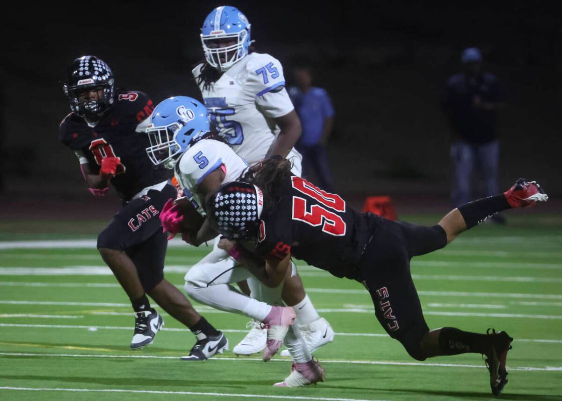 Las Vegas defensive end Leonard Castellanos (50) tackles Centennial running back Khy Harris (5) ...