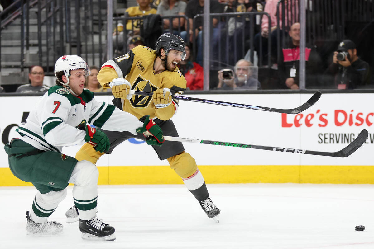 Wild defenseman Brock Faber (7) and Golden Knights defenseman Shea Theodore (27) battle for the ...