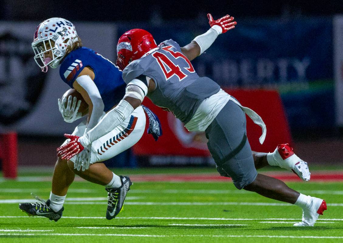 Liberty running back Ezra Sanelivi (1) looks for more yards as Arbor View defensive lineman Don ...